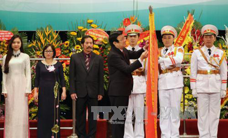 Chủ tịch nước Trương Tấn Sang gắn danh hiệu Anh hùng Lao động lên lá cờ truyền thống của Nhà hát Nghệ thuật đương đại Việt Nam.